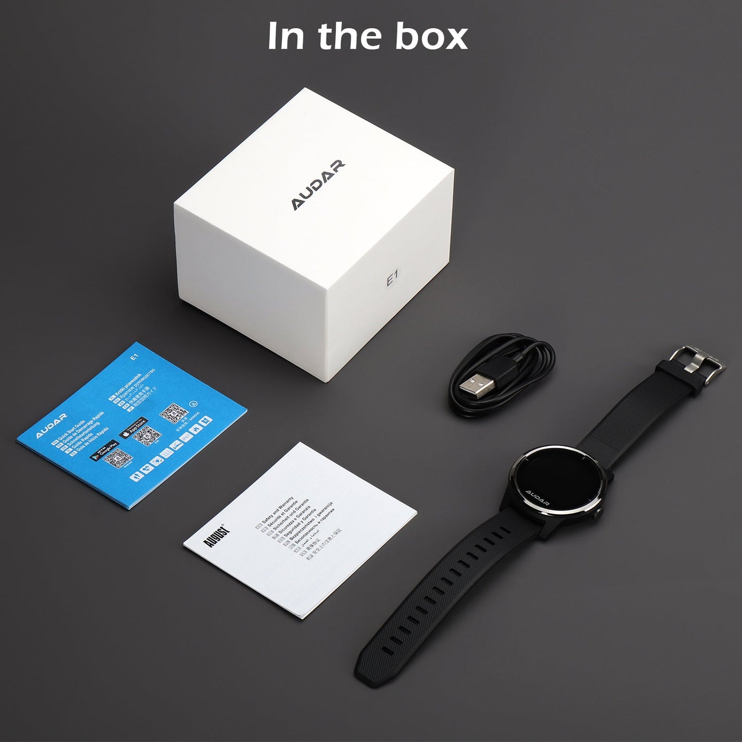 The Box of the E1 is shown to contain the health watch itself, the Magnetic charging USB strip, a Quick Start Guide, and a User Manual